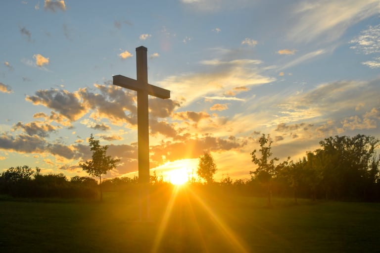 Cross illuminated at sunset, symbolizing faith and community